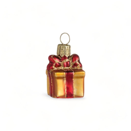 Suspension de Noël en verre soufflé, chromée et peinte à la main en forme de paquet cadeau doré avec un ruban rouge aux liserés dorés pailletés qui se termine par un nœud sur le dessus du cadeau.