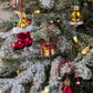 Suspensions de Noël en verre soufflé, chromées et peintes à la main en forme de paquet cadeau doré avec un ruban et nœud rouge, de botte du père Noël rouge garnie de cadeaux, d'une cloche dorée avec des paillettes argentées.