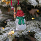 Dos de la suspension de Noël en verre soufflé puis pailleté en forme de bonhomme de neige avec un bonnet rouge et une écharpe verte nouée dans le dos. 