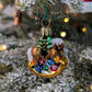 Suspension en verre soufflé, chromée et peinte à la main en forme de cheval à bascule avec une crinière blanche et une selle noire. Il a des paquets cadeaux entre les pattes et un sapin décoré d'une guirlande dorée sur le dos. 