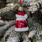 Dos de la suspension en verre soufflé, chromée et peinte à la main en forme de père Noël vêtu de son habit rouge. La fourrure de son habit et de son bonnet est représenté en paillettes blanches.