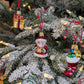 Suspensions en verre soufflé, chromées et peintes à la main en forme de père Noël vêtu de son habit rouge, de gants verts et portant un cadeau doré serti d'un nœud rouge, de paquet cadeau doré serti d'un ruban et nœud rouge, d'une botte du père Noël remplie de paquets cadeaux.