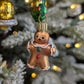 Suspension de Noël en verre soufflé, chromée et peinte à la main en forme de bonhomme en pain d'épices avec ses deux boutons de vêtement, un rouge et un vert, en paillettes. Suspension de Noël en verre soufflé, chromée et peinte à la main en forme de cloche dorée et paillettes argentées.