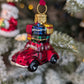 Suspension de Noël en verre soufflé, chromée et peinte à la main en forme de voiture rouge avec des paquets cadeaux rouge, or, bleu et vert sur son toit.