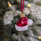 Suspension en verre soufflé, chromée et peinte à la main en forme de bonnet du Père Noël rouge vif, la fourrure est représentée par des paillettes blanches. 