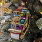 Suspension en forme de traineau du père Noël rouge et doré, garni de paquets cadeaux multicolores. 