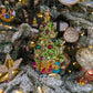Suspension de Noël représentant un sapin de Noël décoré de guirlandes dorée en or 24 carats et de boules de Noël rouges, bleues, or et violettes et d'une étoile dorée au sommet. Des cadeaux bleus, violets et rouges, terminés par un nœud doré sont au pied du sapin.  Suspension en forme d'étoile en broderie d'or avec des paillettes de broderie dorées. Suspension brodée en forme de couronne de noël verte avec un nœud et des perles verts et de la canetille or. Une suspension miniature en  forme de cheval.