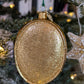 Dos de la suspension de Noël de forme ovale pailletée doré.