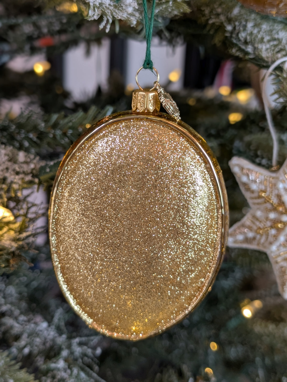 Dos de la suspension de Noël de forme ovale pailletée doré.