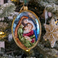 Suspension de Noël de forme ovale représentant un médaillon de la sainte famille : Marie, Joseph et Jésus enfant. 
