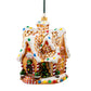 Suspension en forme de maison en pain d'épices décorée de glaçage blanc et de bonbons rouges, verts, bleus et jaunes. Joyeux Noël est écrit sur une pancarte au-dessus de la porte. 